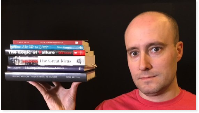 Shane Parrish with a pile of books. Courtesy of Business Insider.